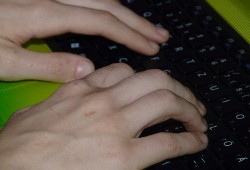 Laptop-Tastatur belegt mit Zehn Fingern.